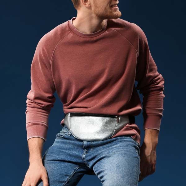 Homem com uma bolsa de cintura amarrada &agrave; volta da cintura sentado num banco - Categoria de bolsas de cintura masculina.