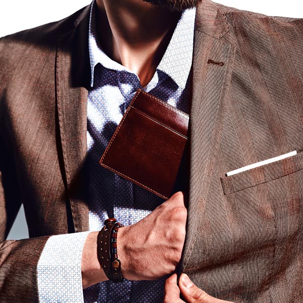 Hombre guardando una bonita cartera de piel marr&oacute;n en el bolsillo de la americana - Categor&iacute;a de carteras para hombre.